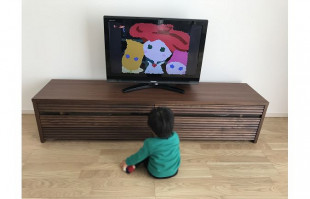 大川家具の無垢テレビボードとテレビを見るお子様(オーキタ家具)