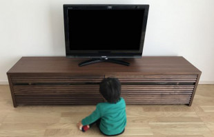 大川家具の無垢テレビボードとテレビを見るお子様(オーキタ家具)