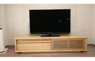 タイル調の壁面に設置されたメイプル色の大川家具のテレビボード(富士家具)