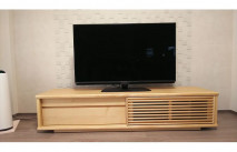 タイル調の壁面に設置されたメイプル色の大川家具のテレビボード