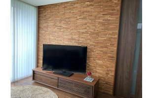 木目調の壁面に設置された大川家具のテレビボード(近新)