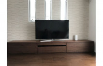 オシャレな明り取りの窓とタイル調の壁面に設置された大川家具の無垢テレビボード