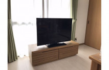 映画を上映中のテレビと大川家具の無垢テレビボード(ヤマケン家具)