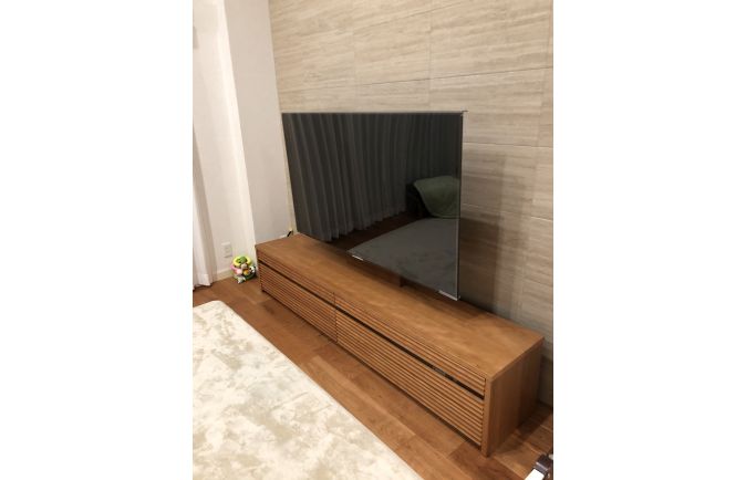 ラグと石張り調の壁面と大川家具のテレビボード(オーキタ家具)