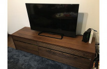 ブルーのラグとウォールナット色の大川家具のテレビボード(オーキタ家具)