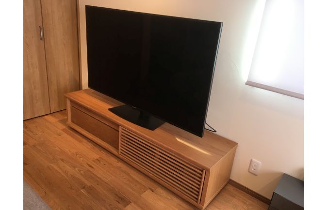 同系色で統一された大川家具のテレビボードと建具やフローリング(オーキタ家具)