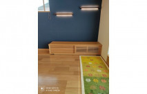 オシャレな照明が付いたブルーの壁面に設置された大川家具のテレビボード(近新近江大橋店)