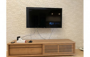 タイル調の壁面に設置された木津川市T.N様の無垢テレビボード(京都展示会)