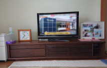 ご家族の写真や置時計が設置された大川家具の無垢テレビボード