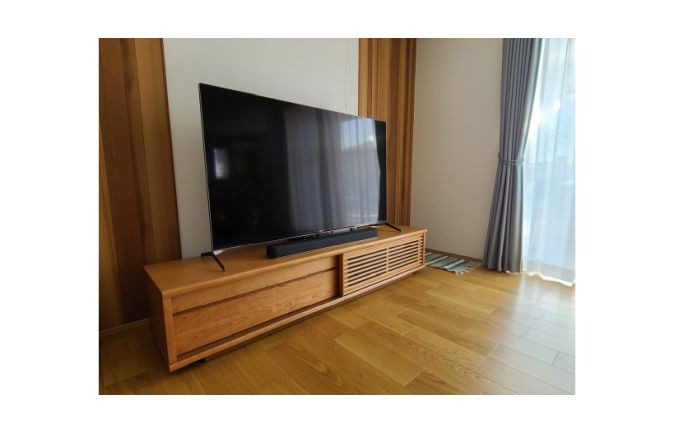 お洒落な木目の壁面とフローリングと大川家具の無垢テレビボード