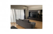 グレー系のハイバックソファと大川家具の壁面収納型テレビボード