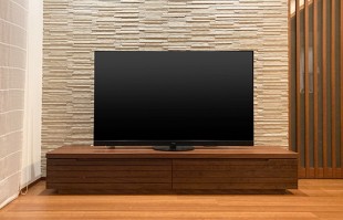 石張り調の壁面に設置された大川家具のテレビボード(ふるなび)