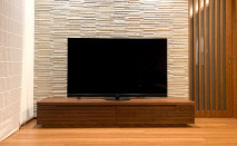 石張り調の壁面に設置された大川家具のテレビボード(ふるなび)